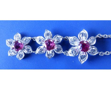 A ruby & diamond triple flowerhead cluster pendant necklace in white metal 