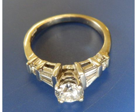 A diamond dress ring, the central claw set stone weighing approximately .75 carat with six small diamonds to shoulders in '18