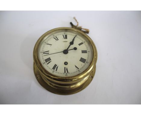 SHIPS CLOCK a ships clock with a brass case and a white enamel dial, with 2 keys and in working order. Dial 15cms diameter, a