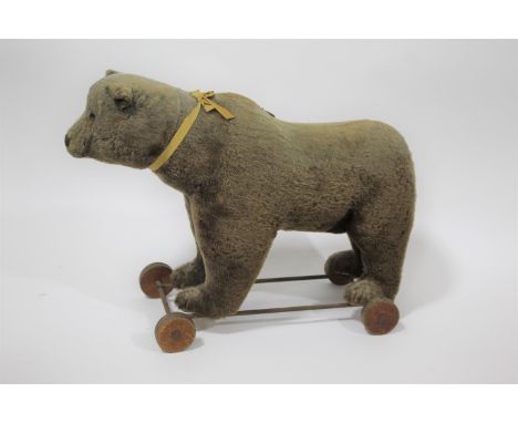 VINTAGE PULL ALONG BEAR possibly by Steiff, the Bear mounted on a metal frame and wooden wheels. With a working growler mecha