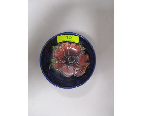 A vintage Moorcroft pin dish having tube lined anemone pattern to cobalt blue ground.