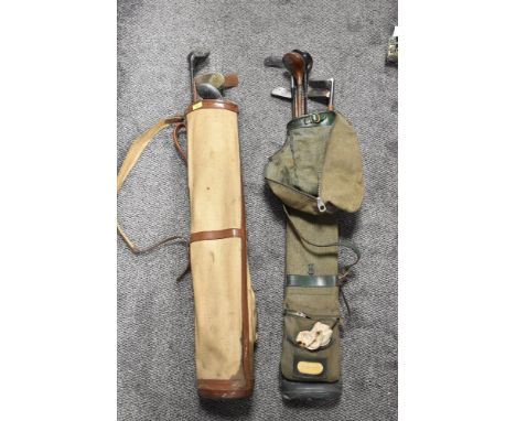 Two vintage canvas golf bags containing hickory shafted golf clubs, metal shafted golf clubs, carved walking stick.