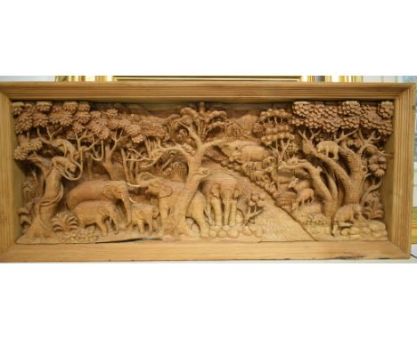 An African carved wood panel, decorated a safari scene with elephants and other animals by a river, 95 cm wide, four prints a
