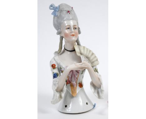 A porcelain half doll, probably Goebel, lady with elaborate grey hair and a white dress with floral decoration, holding a fan