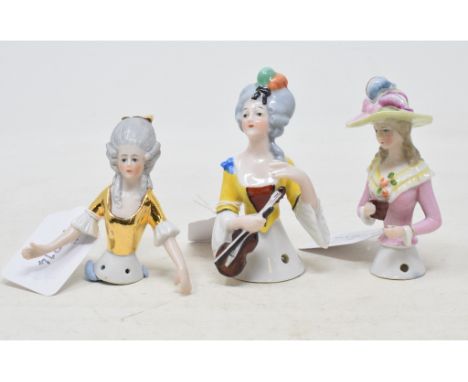 A Goebel porcelain half doll, lady with grey hair wearing a yellow and brown dress, holding a violin, 9 cm high, and two othe