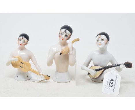 A porcelain half doll, nude pierrot with lute, 11.5 cm high, and two others similar (3) 