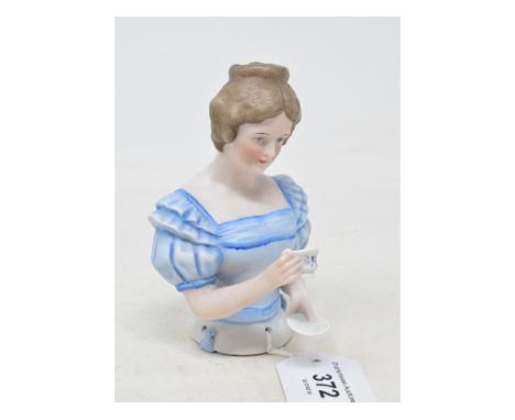 A bisque half doll, lady with short brown hair wearing a light blue dress, holding a cup of tea and saucer, impressed no. 357