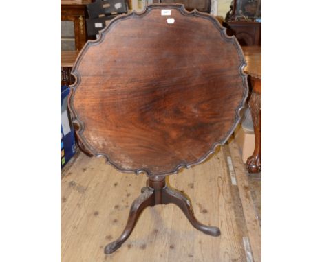 A George III style mahogany tripod table, with a piecrust top, a fluted and reeded vase turned column and leaf carved feet, 8