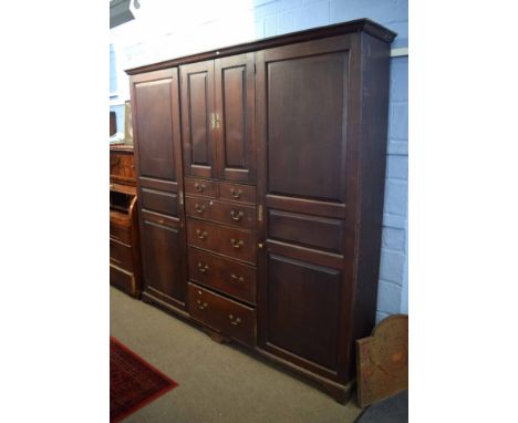 Early 19th century oak housekeeper's cupboard of large proportions, fitted centrally with two cupboard doors over a secretair