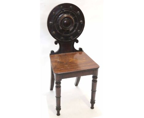 Early Victorian mahogany hall chair with hard seat, ring turned legs, the circular back with raised flowerhead centre