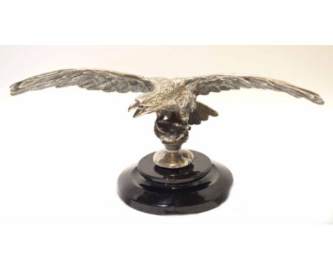 Early/mid-20th century silver plated model of an eagle with wings spread, seated on a ball, black gloss finished ceramic circ