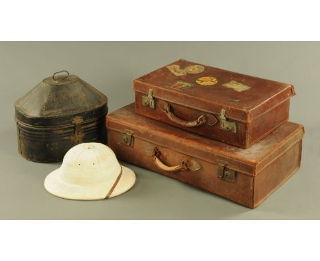 A vintage tin hat box containing a pith helmet, and two leather suitcases. CONDITION REPORT: The hat box is as you see it.  I