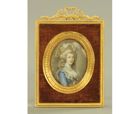 A late 19th/early 20th century portrait miniature on ivory, lady with blue dress in metal frame with ribbon mount, portrait d