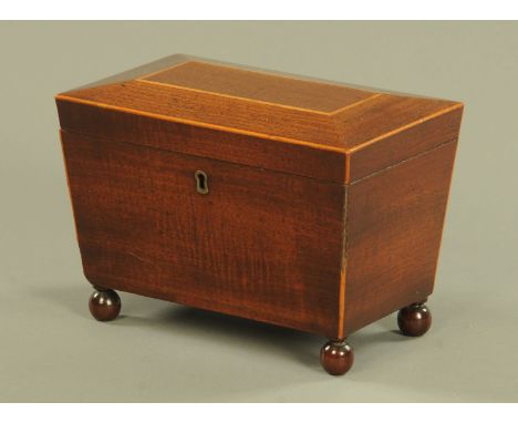 A George III mahogany tea caddy, boxwood strung and raised on four ball feet and with two lidded interior compartments.  Widt