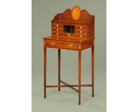 A late 19th century mahogany and inlaid boxwood strung ladies desk, the shaped gallery back having a well figured oval panel 