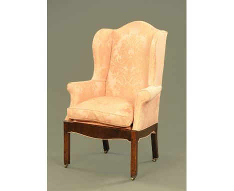 A George II/III oak wing armchair, upholstered in foliate patterned silk and raised on moulded legs of square section termina