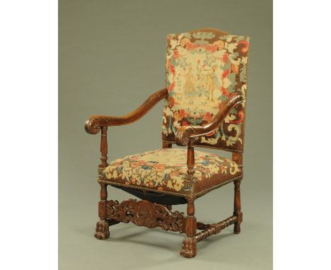 A large late 19th/early 20th century throne type armchair, with tapestry back and seat, carved arms, turned supports and paw 