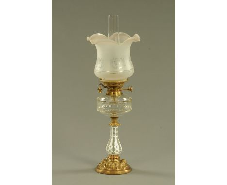 A late 19th century oil lamp, with etched glass shade, clear reservoir and milk glass overlay column.  Height including chimn