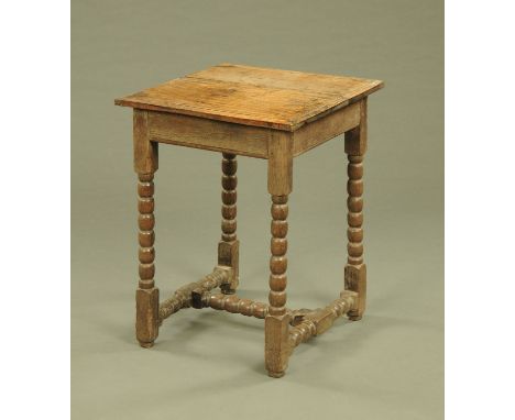 An antique oak table, with moulded edge and raised on bobbin turned legs with single stretcher.  Top 58 cm x 52 cm.