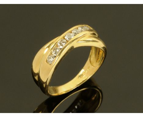 A ladies 18 ct gold crossover ring set with seven diamonds, ring size L, +/- .66 carats of diamonds, 4.2 grams gross weight.