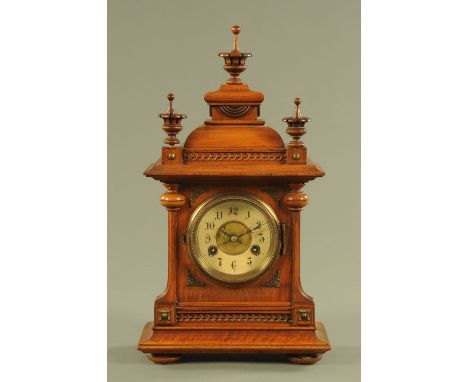 A late Victorian walnut cased mantle clock, with two train striking movement.  Height including finial 46 cm, width 25.5 cm.