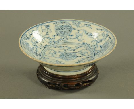 A Chinese Kangxi (1662-1722) footed bowl, with shou and bat marks and raised on a wooden stand.  Diameter 15.5 cm. CONDITION 