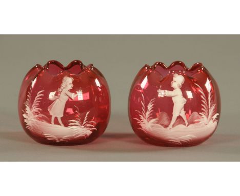 A pair of Mary Gregory style cranberry glass bowls, 19th century, with white enamel decoration of a young boy and girl holdin