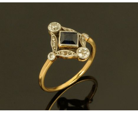 An 18 ct yellow gold Art Deco sapphire and diamond ring, the offset square shaped sapphire flanked by diamonds to each point.