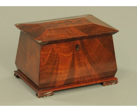 A Regency mahogany tea caddy, of sarcophagus form, with two dome topped interior compartments and raised on short scroll feet