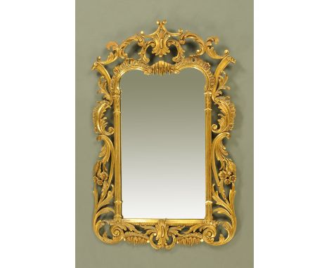 A Chippendale style wall mirror, with foliate and scroll carved frame, circa 1930.  Width 70 cm, height 110 cm.