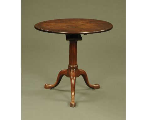 A George III mahogany tripod table, with circular top, snap action and bird cage support with gun barrel column and downswept