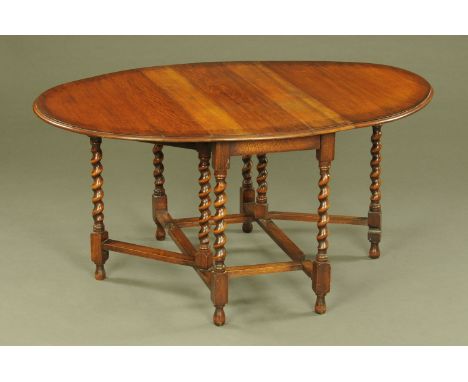 An oak gate legged dining table, oval, twin drop flap with barley sugar twist supports and stretchers.  Length extended 150 c