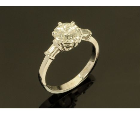 An 18 ct white gold ring, set with a diamond to the centre and with baguette shoulders.  Total weight +/- 1.64 carats.  Size 