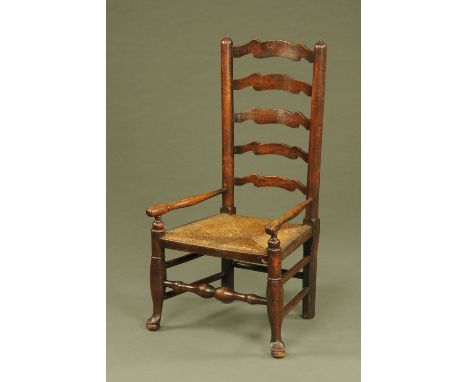 A 19th century ladder back rush seated low chair, raised on turned front legs terminating in pad feet.  Width across arms 53 