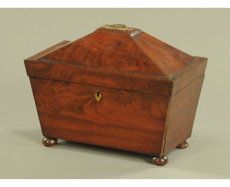A Regency mahogany tea caddy, with brass carrying handle and three interior lidded lead lined compartments and raised on bun 