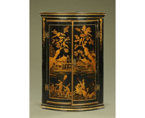 A 19th century hanging bowfronted corner cupboard, with chinoiserie decoration, the doors opening to shaped painted shelves. 