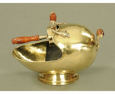 A 19th century brass coal helmet, with scoop, with turned wooden handles.  Length 48 cm, height 36 cm.