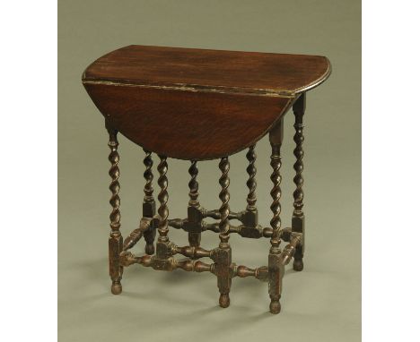 An early 20th century oak small twin drop flap oval gate leg occasional table, with twist column supports.  Width 66 cm, leng