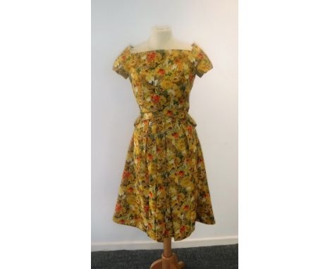 CHRISTIAN DIOR; A SILK DAY DRESS CIRCA 1950'S, the material printed with red & yellow summer flowers, cross over detail to bo