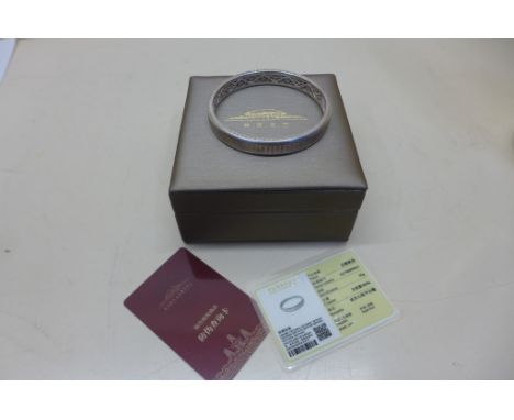 A Chinese white metal bangle with rotating outer - 35 grams, with certificates and box 