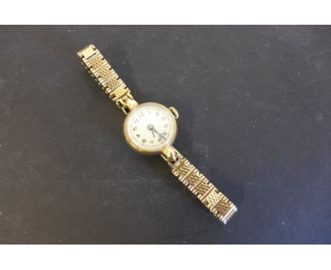 A 9ct yellow gold ladies manual wind wristwatch on a 9ct strap, total weight approx 17 grams 