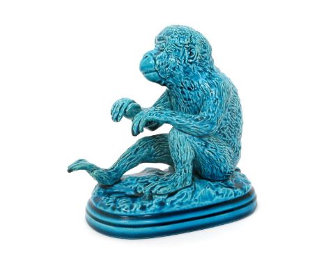 A Burmantofts Faience model of a monkey, modelled seated, covered in a Turquoise blue monochrome glaze impressed marks, 15cm.