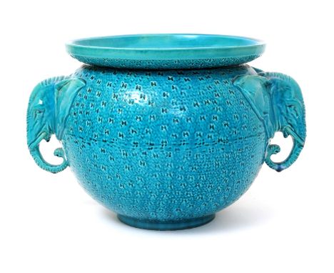 A Burmantofts Faience jardiniere, ovoid with everted rim, modelled with two elephant mask handles and textured surface, glaze