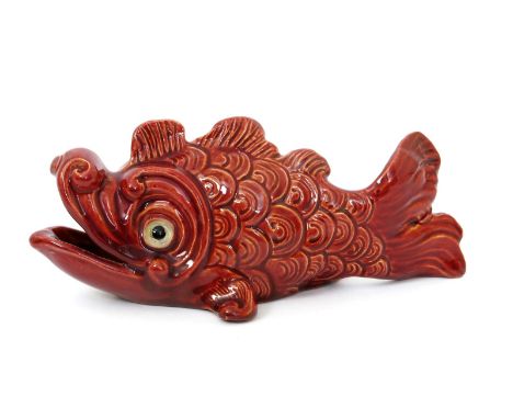 A Burmantofts Faience model of a scaly fish, model no.2166, covered in a sang de boeuf glaze, with applied glass eyes impress