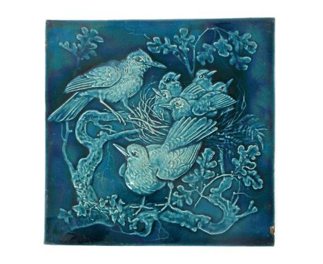 A large Burmantofts Faience architectural tile, modelled in low relief with a nest of birds perched on an oak bough, glazed b