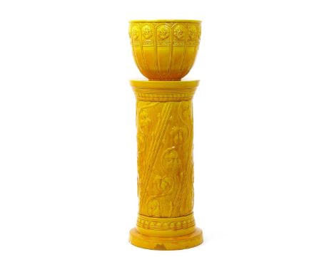 A Burmantofts Faience jardiniere and stand, model no.944 and 1780, the cylindrical stand cast in low relief with columns of i