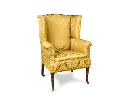 A Regency mahogany wingback armchair, upholstered in yellow damask, on ring turned legs with ceramic castors108 x 76 x 67cmCo