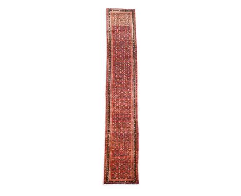 A Persian red ground runner, late 20th century,  with repeating herati design on a madder ground 535 x 84cm  The carpet is in