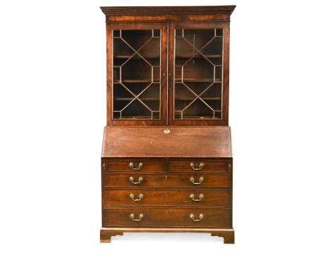 A late George III mahogany bureau bookcase, the moulded cornice above a pair of glazed doors enclosing shelves, the crossband