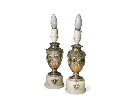 A matched pair of silver and alabaster mounted urns, later converted to electric table lamps, each raised on alabaster bases 